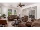Bright living room with plush sofas, a ceiling fan, and neutral decor, providing a comfortable and welcoming space for gatherings at 20409 W Thayer St, Buckeye, AZ 85396