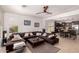 Open concept living room with a brown sectional sofa, tile flooring, and views into the kitchen area at 20409 W Thayer St, Buckeye, AZ 85396