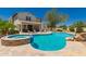 Stunning backyard pool with attached spa, lush desert landscaping, and patio area at 20409 W Thayer St, Buckeye, AZ 85396