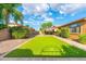 Expansive backyard featuring a green lawn, mature landscaping, and a covered patio offering the perfect outdoor escape at 2124 W Harwell Rd, Phoenix, AZ 85041