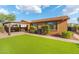 Landscaped backyard showcasing a green lawn, covered patio, and meticulous desert landscaping creating an inviting outdoor area at 2124 W Harwell Rd, Phoenix, AZ 85041