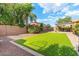 Well-maintained backyard with green lawn, desert landscaping, and a covered patio perfect for enjoying the Arizona weather at 2124 W Harwell Rd, Phoenix, AZ 85041