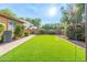 Lush green lawn surrounded by brick pavers and mature landscaping providing a private and serene backyard oasis at 2124 W Harwell Rd, Phoenix, AZ 85041