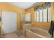 Bright bathroom showcases tile flooring, a glass shower, and a large soaking tub by a window at 2124 W Harwell Rd, Phoenix, AZ 85041