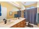 Bathroom with double sinks, a large mirror, and a shower behind a gray curtain at 2124 W Harwell Rd, Phoenix, AZ 85041