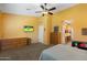Bright bedroom with carpet features a flat-screen television, a dresser, and an entrance to the bathroom at 2124 W Harwell Rd, Phoenix, AZ 85041
