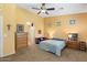 Bedroom boasts a neutral carpet and furnishings, a ceiling fan, and access to the ensuite bathroom at 2124 W Harwell Rd, Phoenix, AZ 85041
