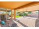 Relaxing covered patio with ample space, stylish brick pavers, ceiling fan, and backyard views through sliding glass door at 2124 W Harwell Rd, Phoenix, AZ 85041
