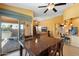 Cozy dining area with a large wooden table, ceiling fan, and access to an outdoor patio at 2124 W Harwell Rd, Phoenix, AZ 85041