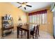 Cozy dining room with warm yellow walls, a ceiling fan, and a dark wood table set for four at 2124 W Harwell Rd, Phoenix, AZ 85041