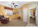 Comfortable living room with a brown leather recliner, ceiling fan, and access to another room at 2124 W Harwell Rd, Phoenix, AZ 85041
