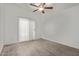Bright bedroom featuring wood-look tile flooring, ceiling fan, and sliding glass door at 22039 N 35Th Dr, Glendale, AZ 85310