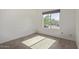 Bright bedroom featuring wood-look tile flooring and a large window overlooking the street at 22039 N 35Th Dr, Glendale, AZ 85310