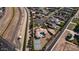 Aerial view of estate with a pool, tennis court, and desert landscaping in a residential neighborhood at 3126 E Fruitvale Ct, Gilbert, AZ 85297