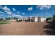 The back of the house with mature landscaping, trees, and a view of the tennis court and grassy lawn at 3126 E Fruitvale Ct, Gilbert, AZ 85297