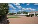 View of backyard, featuring tennis court and grassy lawn with mature trees and white-exterior house at 3126 E Fruitvale Ct, Gilbert, AZ 85297