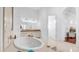 Bright bathroom featuring a soaking tub, double vanity, and an open doorway to the Primary bedroom at 3126 E Fruitvale Ct, Gilbert, AZ 85297