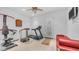 Home gym featuring a variety of exercise equipment, tiled floor, and bright lighting promoting a healthy lifestyle at 3126 E Fruitvale Ct, Gilbert, AZ 85297