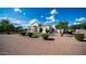 Well-manicured circular driveway of home surrounded by grass, bushes, rocks, and palm trees at 3126 E Fruitvale Ct, Gilbert, AZ 85297