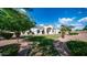 Beautifully landscaped yard with mature tree in front of elegant home with arched windows and decorative door at 3126 E Fruitvale Ct, Gilbert, AZ 85297