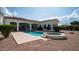 An in-ground pool and jacuzzi with the back of a white house, featuring an arched patio and manicured lawn at 3126 E Fruitvale Ct, Gilbert, AZ 85297