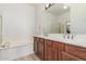 Bathroom features a large soaking tub, wood cabinets and dual vanity at 3131 E Legacy Dr # 2113, Phoenix, AZ 85042