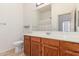 Bathroom with wood vanity, white countertop, a large mirror, and an open door view to the bath tub at 3131 E Legacy Dr # 2113, Phoenix, AZ 85042