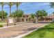 Gated community entrance featuring lush landscaping, a stately gate, and palm tree lined street at 3131 E Legacy Dr # 2113, Phoenix, AZ 85042