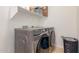 Convenient laundry room with modern gray front-load washer and dryer set with shelf at 3131 E Legacy Dr # 2113, Phoenix, AZ 85042