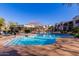 Community pool with lounge chairs, umbrellas, and landscaped surroundings at 3131 E Legacy Dr # 2113, Phoenix, AZ 85042