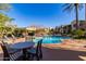 Community pool with lounge chairs, umbrellas, and landscaped surroundings at 3131 E Legacy Dr # 2113, Phoenix, AZ 85042