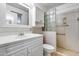 Classic bathroom with white vanity, large mirror, and shower with glass block partition at 3251 W Mercer Ln, Phoenix, AZ 85029
