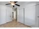 Bedroom with tile floors, white walls, a ceiling fan, and a closet with sliding doors at 3251 W Mercer Ln, Phoenix, AZ 85029