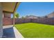 Backyard with artificial grass and a covered patio at 3313 W Wayland Dr, Phoenix, AZ 85041