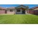 Backyard featuring artificial grass, desert landscaping, and a covered patio at 3313 W Wayland Dr, Phoenix, AZ 85041