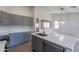 Bright kitchen featuring stainless steel appliances, gray cabinets and a large kitchen island at 3313 W Wayland Dr, Phoenix, AZ 85041