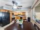 Eat in kitchen featuring wooden cabinets, tile backsplash and black appliances at 4122 W Las Palmaritas Dr, Phoenix, AZ 85051