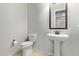 Simple powder room with a pedestal sink and a toilet in a clean, neutral setting at 4173 E Jones St, Gilbert, AZ 85295