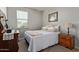 Bedroom with a full bed with decorative pillows, a small nightstand, and bright window at 4173 E Jones St, Gilbert, AZ 85295