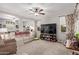 Spacious living room with a plush sofa, ceiling fan, and large windows with decorative curtains at 4173 E Jones St, Gilbert, AZ 85295