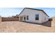 Backyard view of white house with covered patio, and privacy wall at 42510 W Peters Dr, Maricopa, AZ 85138