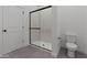 Modern bathroom with a sleek glass-enclosed shower and tiled floors at 42510 W Peters Dr, Maricopa, AZ 85138