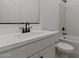 Bright bathroom with white cabinets, large countertop, and black hardware at 42510 W Peters Dr, Maricopa, AZ 85138