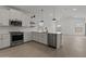 Modern kitchen with white cabinets, stainless steel appliances, a center island and wood flooring at 42510 W Peters Dr, Maricopa, AZ 85138