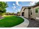 Well-maintained backyard with grassy lawn, lush greenery, and a paved walkway for outdoor enjoyment at 4326 E Cloudburst Ct, Gilbert, AZ 85297