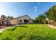 The large backyard offers a lush lawn, mature trees and a play structure, perfect for outdoor activities at 4326 E Cloudburst Ct, Gilbert, AZ 85297