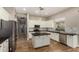 Bright kitchen features white cabinets, stainless steel appliances, island with dark countertops, and wood-look flooring at 4326 E Cloudburst Ct, Gilbert, AZ 85297