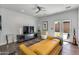 Cozy living room featuring a stylish yellow sofa, a ceiling fan, and access to the backyard area at 4435 N 35Th St, Phoenix, AZ 85018