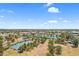Wide aerial view showcasing a neighborhood with tennis courts, green spaces, and a picturesque community lake at 4615 W Del Rio St, Chandler, AZ 85226