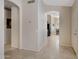 Inviting hallway with neutral walls, tiled floor, and arched doorways leading to kitchen and front door at 4615 W Del Rio St, Chandler, AZ 85226
